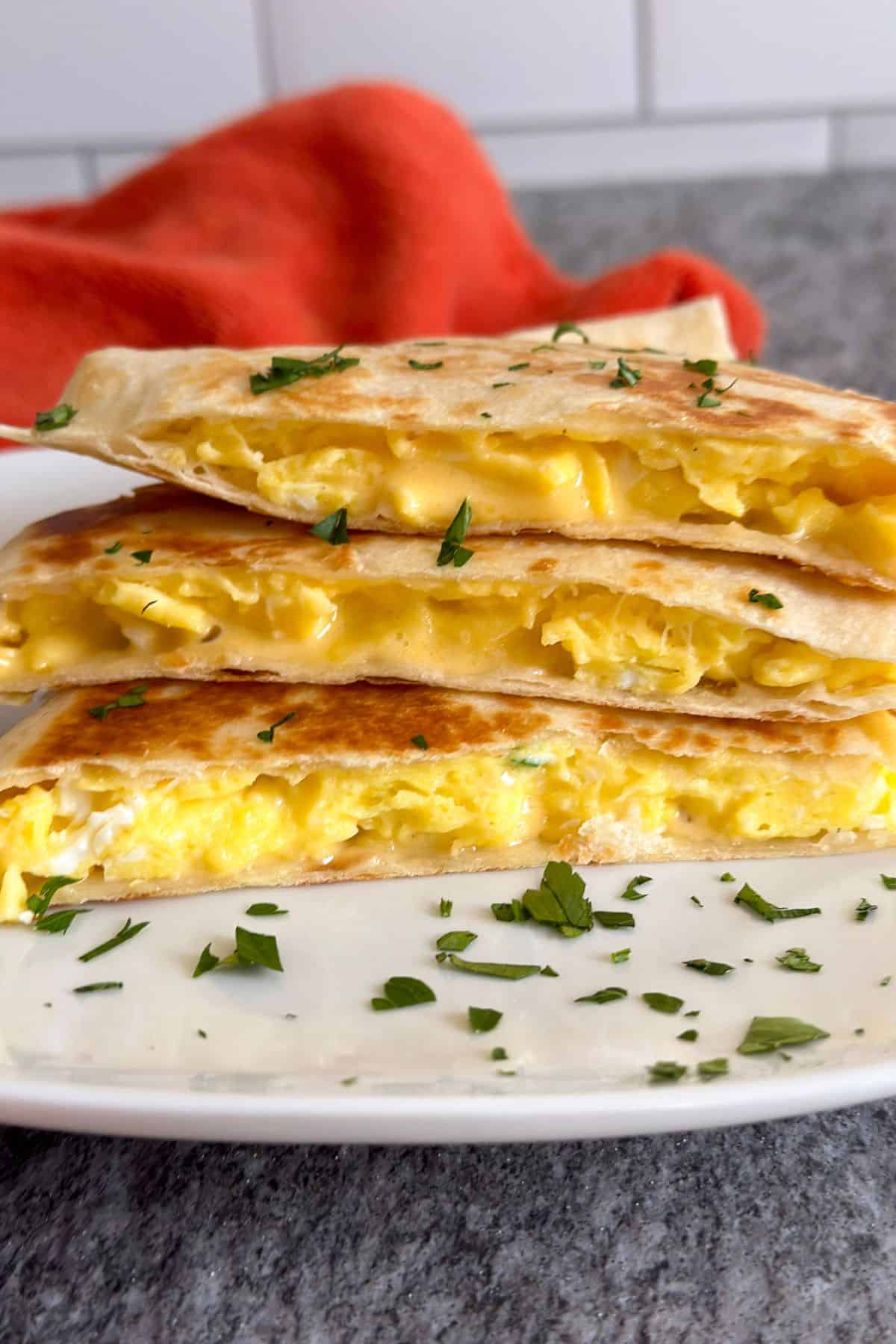 Scrambled egg and cheese breakfast quesadilla on a white plate