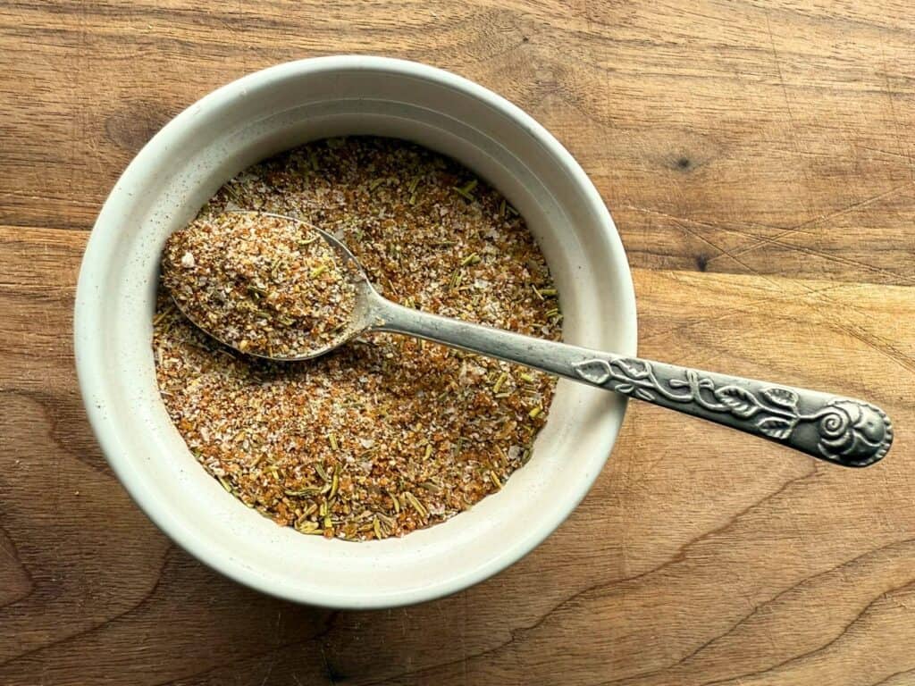 Dry turkey rub seasoning in a small white bowl with a silver spoon