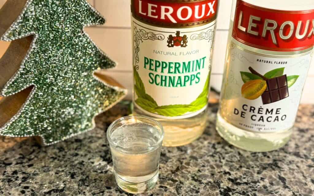 A shot glass with a polar bear shot and the bottled ingredients behind it